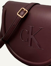 BOLSO CALVIN KLEIN RAISED CK SADDLE CROSSBODY en color Burdeos
